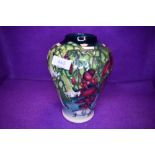 A large Moorcroft vase of baluster form having cream, green and blue ground with floral pattern in