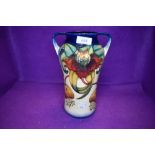 A large Moorcroft twin handled lily vase having cream and blue ground with lily pattern in ochre,