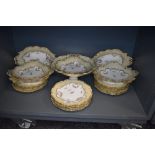 A selection of antique porcelain plates and serving dishes in a Rockingham design having cream and