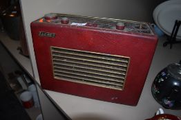 A vintage red vinyl clad Hacker Herald radio.