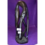 An unusual ethnic wood treen carved figure or totem of an creature eating itself