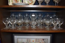 A large selection of glasses including gin glasses and etched examples.