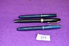 Two Parker Slimfold fountaiin pens in blue with single decorative band to cap, and a Sheaffer in