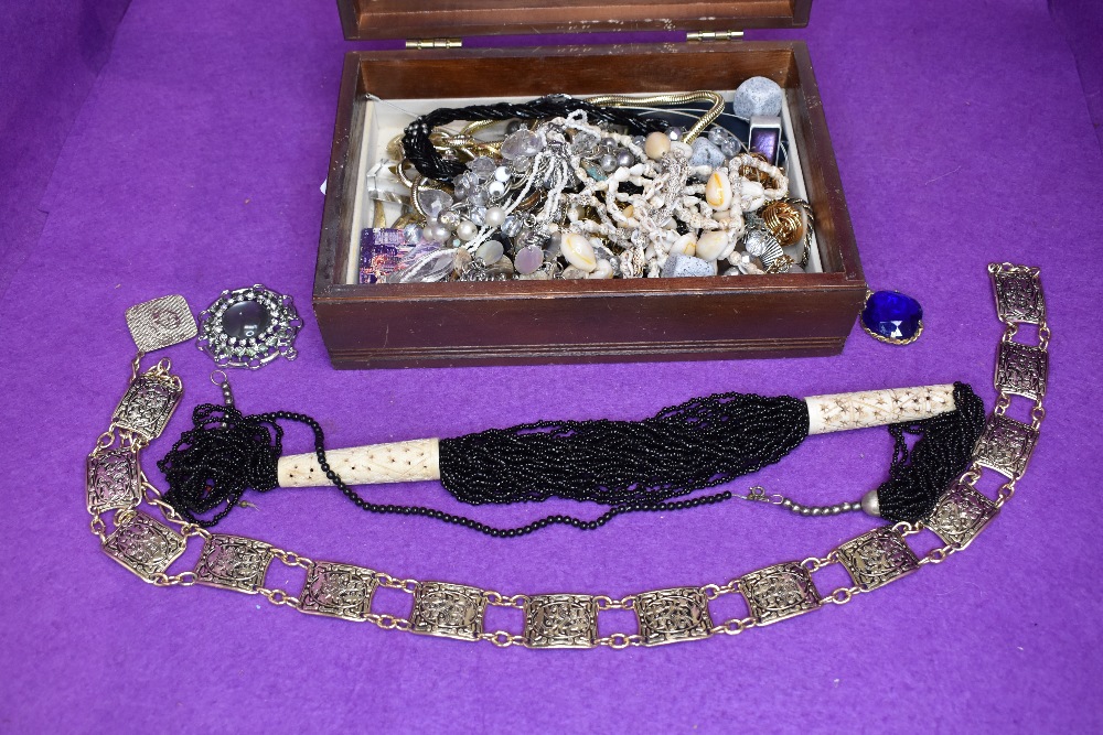 A wooden box containing a selection of costume jewellery necklaces