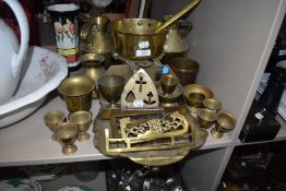 A mixed lot of vintage brass, including trivet, pan, egg cups, spice rack and more.