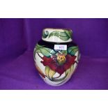 A large Moorcroft Anna lily ginger jar having cream ground with red and yellow lily design.