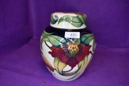 A large Moorcroft Anna lily ginger jar having cream ground with red and yellow lily design.