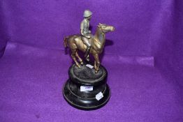 A vintage bronze effect horse and rider mounted on wooden plinth, possibly of military interest.