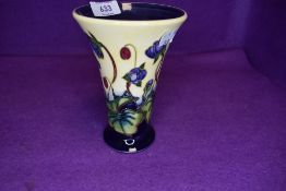 A Moorcroft Hepatica vase having floral pattern on cream ground.