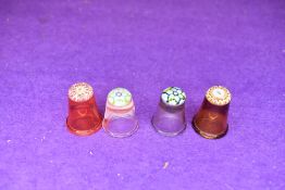 A selection of four fine and detailed miniature glass makers thimbles having various designs