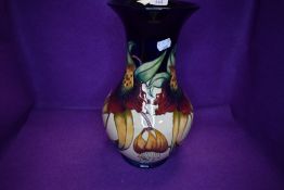 A very large Moorcroft Tiger lily vase having cream and blue ground with lily pattern in ochre,green