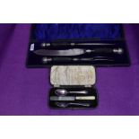 A cased three piece carving set having black antler handles with white metal finials, James