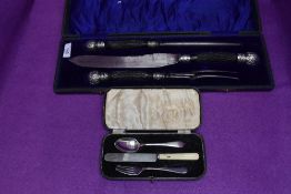 A cased three piece carving set having black antler handles with white metal finials, James