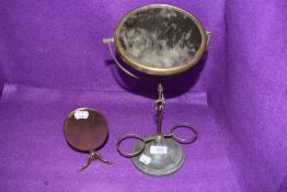 An antique brass mirror and another later vintage shaving mirror.