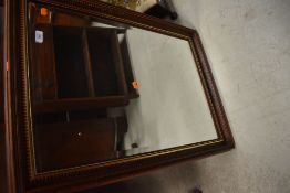 A modern mahogany effect wall mirror, approx. 85 x 61cm