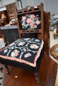 A Victorian mahogany nursing chair having turned frame and later woolwork seat and back