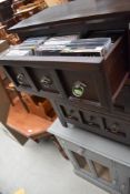 A modern mahogany effect set of three CD drawers, in a medieval style, containing eclectic mix of