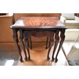 An early 20th Century flame mahogany nest of table having shaped top and cabriole legs