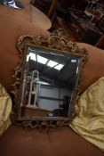 An antique gilt and gesso carved wood frame mirror with bevel edged glass