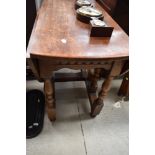 A traditional oak gateleg dining table on turned frame