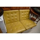 A pair of vintage mustard vinyl easy chairs having button seats