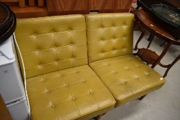 A pair of vintage mustard vinyl easy chairs having button seats