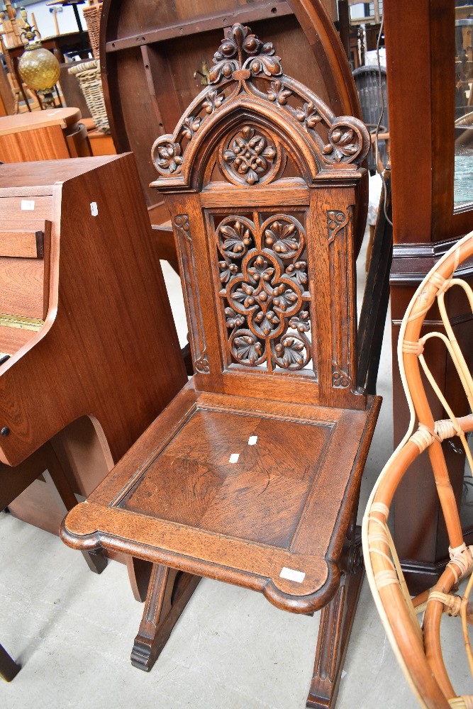 A 19th century Gothic Revival oak ecclesiastical chair having solid seat and naturalistic decoration