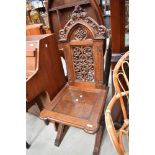 A 19th century Gothic Revival oak ecclesiastical chair having solid seat and naturalistic decoration
