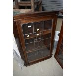 An early 20th Century stained frame corner wall display having leaded glass door