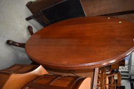 A Victorian mahogany snap top dining table, oval top over turned column and quadruple scroll legs,