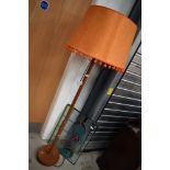A vintage standard lamp with orange pom pom shade