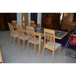 A modern beech effect extending dining table having frosted effect glass top and a set of six