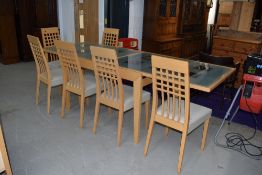 A modern beech effect extending dining table having frosted effect glass top and a set of six