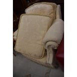 A traditional upholstered armchair in cream