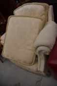 A traditional upholstered armchair in cream