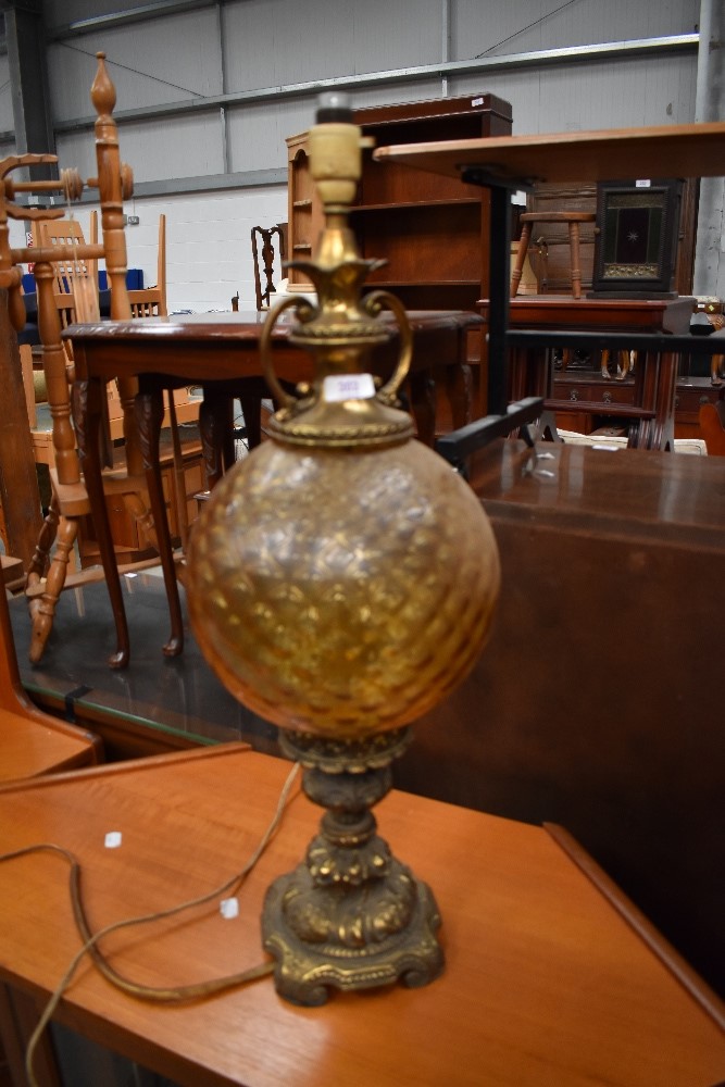 An antique ormolou lamp having detailed cast base with textured yellow glass balloon body