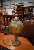 An antique ormolou lamp having detailed cast base with textured yellow glass balloon body