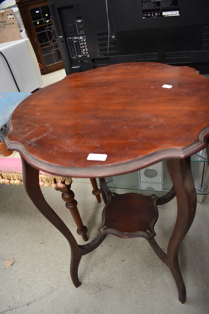 An early 20th Century mahogany occasional table having shaped top, legs and undertier, width approx.