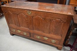 A Georgian oak 4 panel kist having drawer base, brass handles and escutcheons, bracket feet,