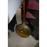 A traditional copper and brass warming pan