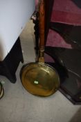 A traditional copper and brass warming pan