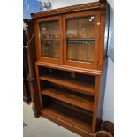 A late Victorian oak bookcase with glazed cabinet over open shelves, width approx. 114cm
