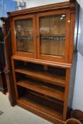 A late Victorian oak bookcase with glazed cabinet over open shelves, width approx. 114cm