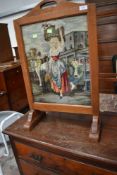 An early 20th Century firescreen having pictorial woolwork panel