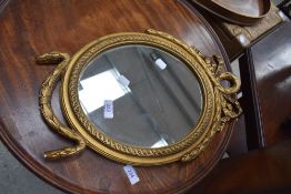 A vintage reproduction gilt plaster wall mirror of smal proportions, having swag decoration, bears