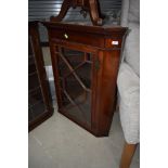 A late Victorian/Edwardian mahogany corner wall display cabinet having astral glazed door