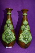 A pair of art Nouveau vases having green man/nature spirit motifs to front with leaf pattern on