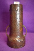 An arts and crafts hammered copper twin handled vase, embossed WME G to underside.