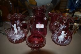 A selection of antique cranberry glass wares including hand decorated Mary Gregory style