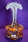 A bold piece of art glass having fluted neck and orange, aubergine and white running through the